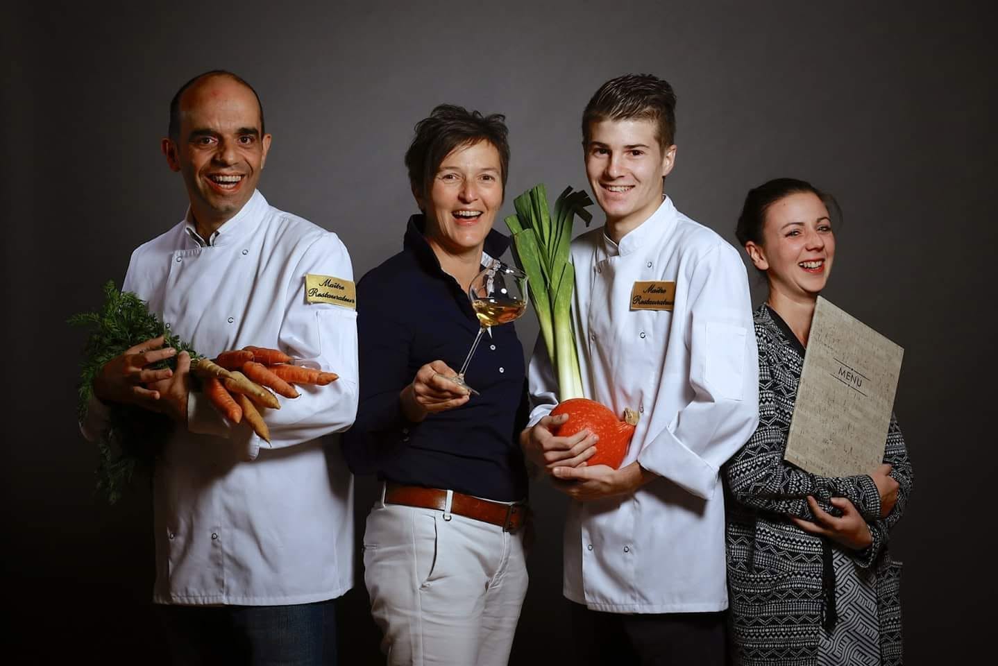 A smiling team holding fresh produce